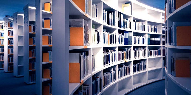 rows of illuminated catalogs and white modern book cases against a blue background